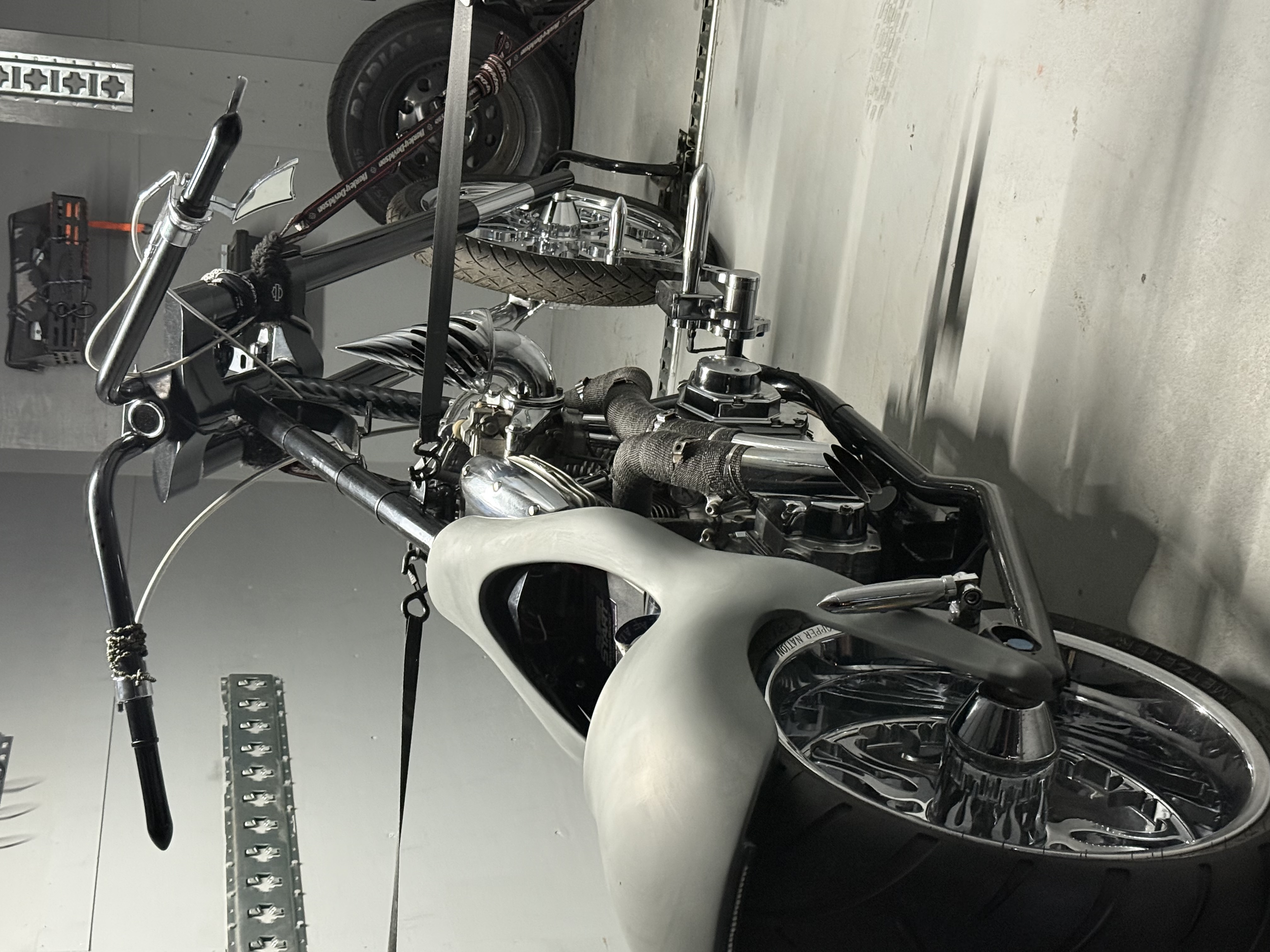 Custom chopper motorcycle with high handlebars properly secured in trailer with tie-down straps
