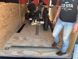 Motorcycle loading process demonstration showing proper positioning in trailer